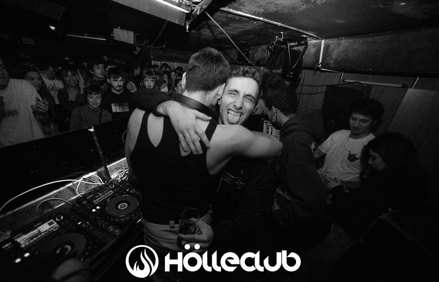 Abrazo junto a la cabina de DJ, rodeado del público de HÖLLE Club.
