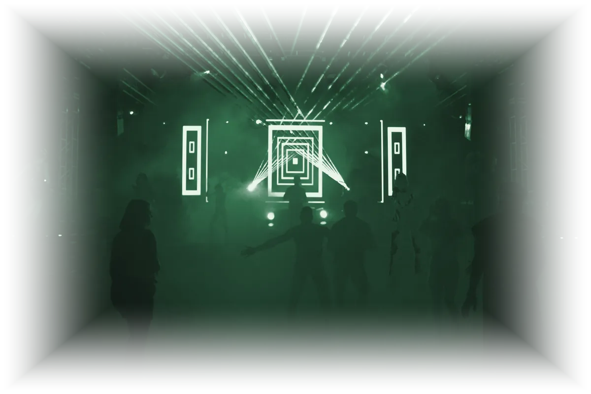Público en silueta bailando entre láseres y humo