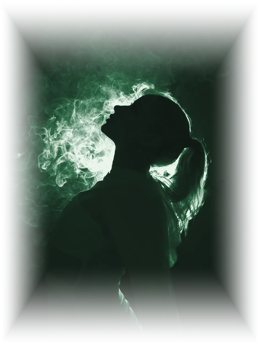 Silueta de una persona bailando entre humo y contraluz