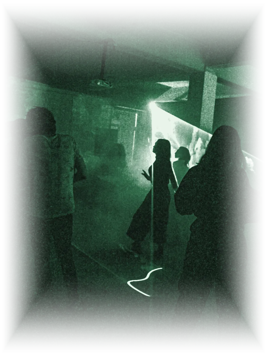 Siluetas bailando en una nave con humo y un haz de luz